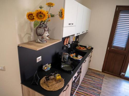 a kitchen with a counter with a vase of flowers at Sicilia Bedda - B&B - Rooms - Apartments in Santo Stefano di Camastra