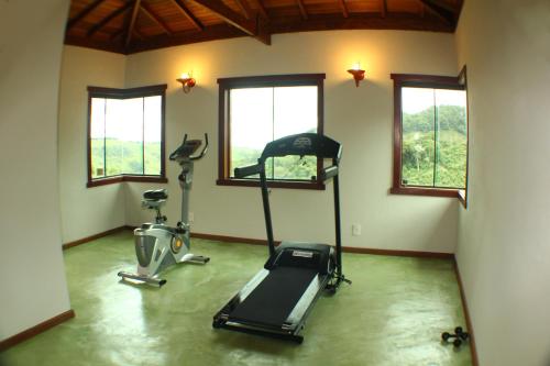 a gym with a treadmill and exercise bikes in a room at Pousada Villa dos Leais in Serra Negra