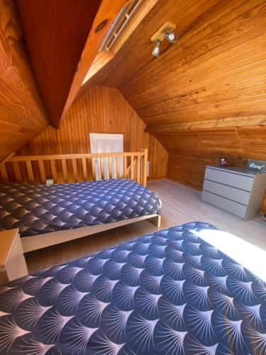 una camera con letto e soffitto in legno di Maison avec jardin 4 à 5 personnes a Mers-les-Bains