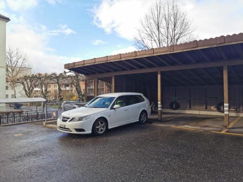 une voiture blanche garée devant un immeuble dans l'établissement Simple Studio 36m2 in the Center of Burgdorf private Parking SMALL BATHROOM, à Burgdorf