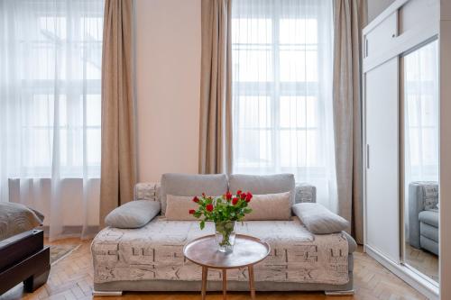 sala de estar con sofá y mesa con flores en Premium Wenceslas Square Apartments, en Praga