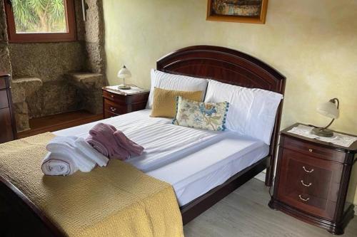 a bedroom with a large bed with a wooden headboard at Lugar encantador com estacionamento incluído in Reboreda