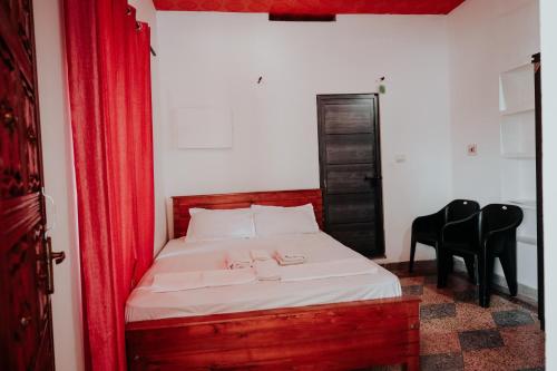 - une chambre avec un lit doté de rideaux et de chaises rouges dans l'établissement kaffee valley homestay, à Padinjarathara