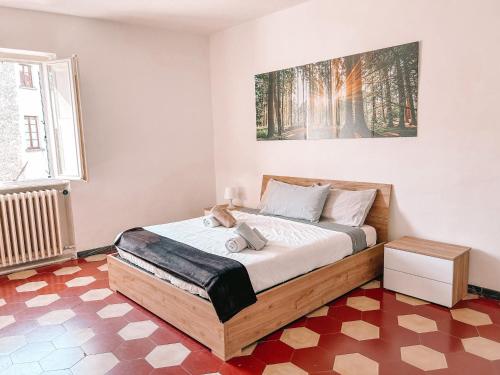 una camera con un letto con una foto sul muro di Attico Il Magnifico Volterra a Volterra