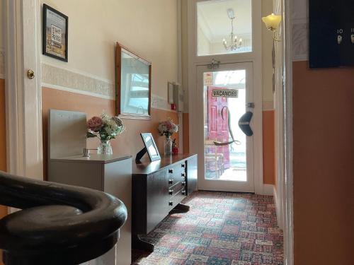 pasillo con silla, escritorio y puerta en The Langham, en Weymouth