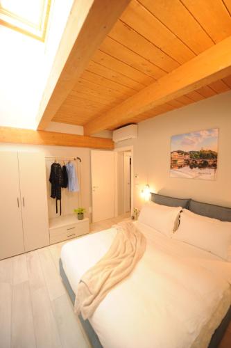 a bedroom with a white bed with a wooden ceiling at Bene39 in Turin