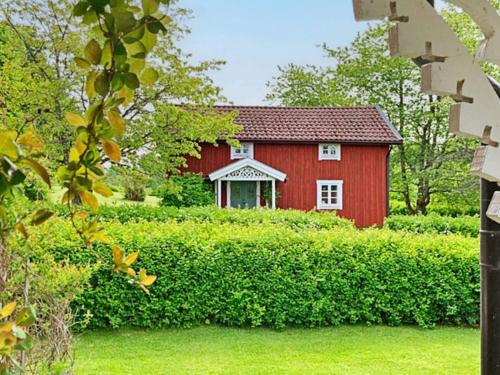 a red barn in the middle of a field at 5 person holiday home in BODAFORS-By Traum in Bodafors