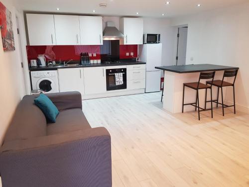 a living room with a couch and a kitchen at Central Windsor 2 bedroom flat with free parking in Windsor