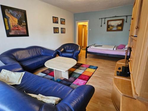 a living room with a couch and a table and a bed at Eigener Eingang, 1-Zimmer mit Bett und große Wohnküche mit Schlafcouch in Oberhausen