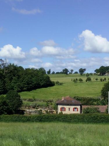 a house in the middle of a green field at Clos de l'Arthonnet in Flavignac
