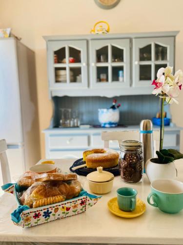 a kitchen table with pastries and cups on a counter at Casa Mary in Fregene