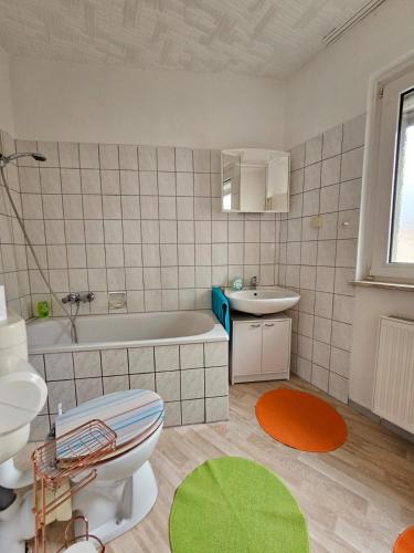 a bathroom with a tub and a toilet and a sink at Eigener Eingang, 1-Zimmer mit Bett und große Wohnküche mit Schlafcouch in Oberhausen