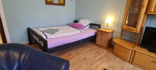 Un pequeño dormitorio con una cama y un televisor. en Eigener Eingang, 1-Zimmer mit Bett und große Wohnküche mit Schlafcouch, en Oberhausen