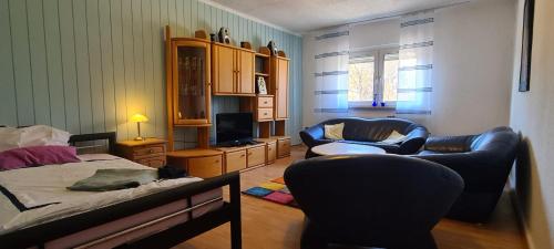 1 dormitorio con cama, sofá y sillas en Eigener Eingang, 1-Zimmer mit Bett und große Wohnküche mit Schlafcouch, en Oberhausen