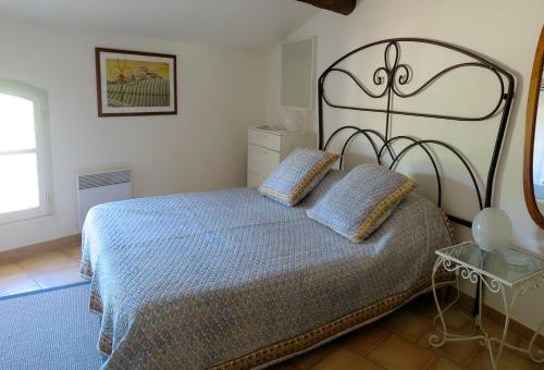 a bedroom with a bed with a blue comforter at Spectacular Views - Sablet in Sablet
