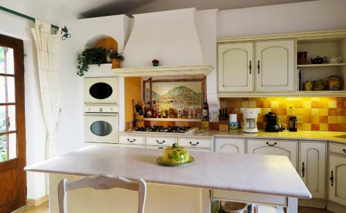 a kitchen with white cabinets and a table in it at Spectacular Views - Sablet in Sablet