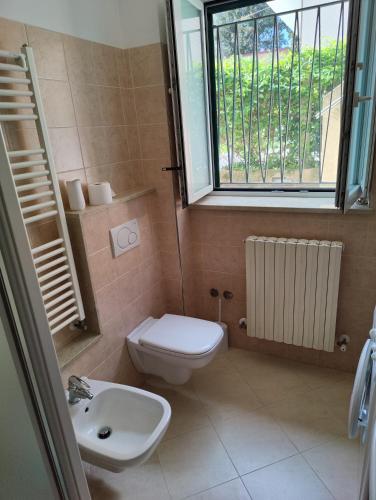 a bathroom with a toilet and a sink and a window at Casa Venezia in Senigallia