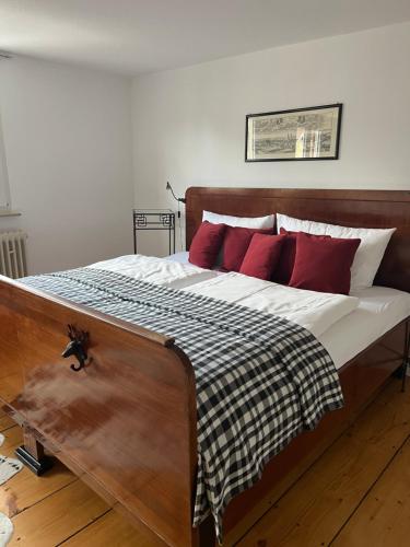 キッペンハイムにあるApartment Auerbacherのベッドルーム1室(大型木製ベッド1台、赤い枕付)
