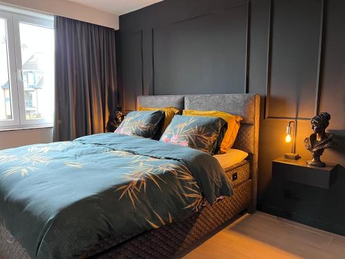1 dormitorio con 1 cama con edredón azul y ventana en Red cross street en Lommel