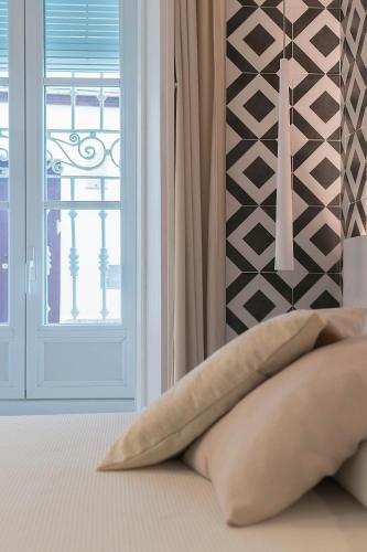 a pillow sitting on a bed next to a window at La Casa del Arco in Conil de la Frontera