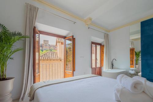 a bedroom with a bed and a tub and a window at Casa de la Acequia by Florentia Homes in Granada