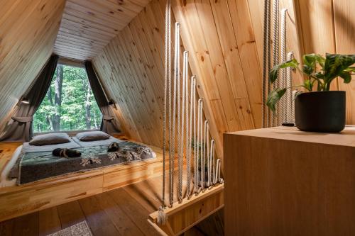 uma cama num quarto de madeira com uma janela em Kabinka Mátra em Pásztó