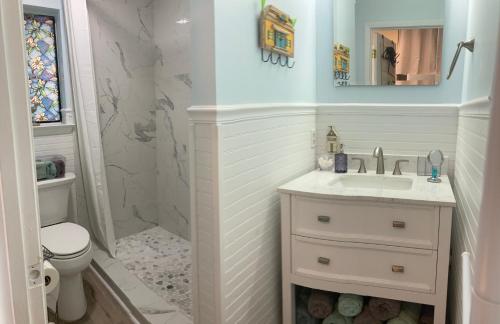 W łazience znajduje się umywalka, toaleta i lustro. w obiekcie Sunset Harbor Condo for 2-TOP FLOOR 1-309, Navarre Beach w mieście Navarre