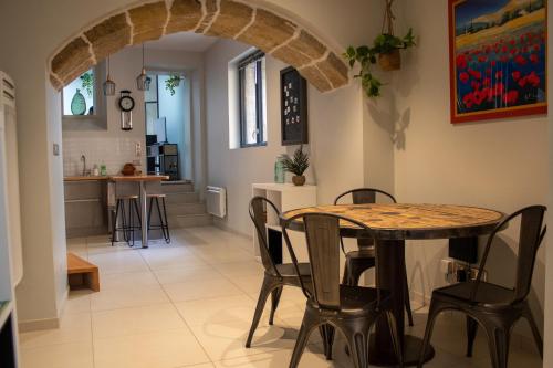 ein Esszimmer und eine Küche mit einem Tisch und Stühlen in der Unterkunft Le Triplex - 4 pers - Wifi - Centre ville in Mende