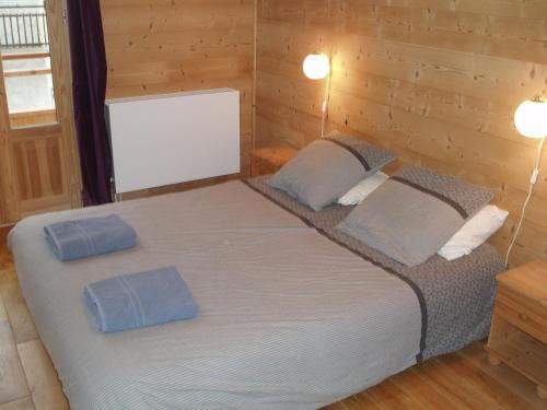 a bedroom with a large bed with two blue pillows at Chalet Rum Doodle in Pralognan-la-Vanoise