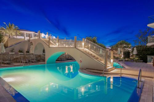 a bridge over a swimming pool at night at Katerina Palace Studio 1 in Argassi