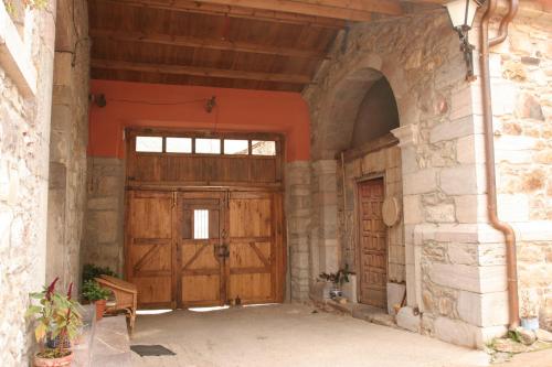 uma entrada para um edifício com duas portas de madeira em Apartamentos Rurales CASONA DE LOLO em Caunedo