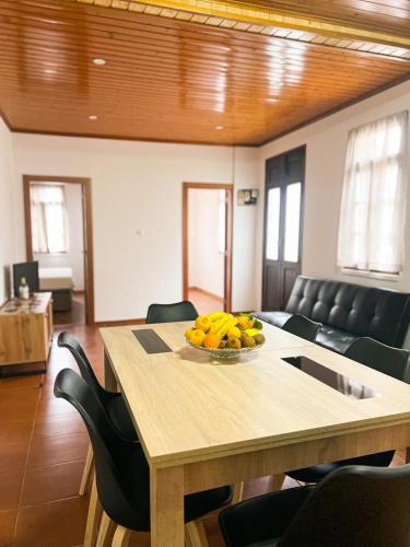 a dining room table with a bowl of bananas on it at Casinha Ponte Nova in Monção