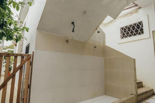 pared blanca con ducha en un edificio en Pargo, habitación privada de Flor de Lis Beach House, en Playas