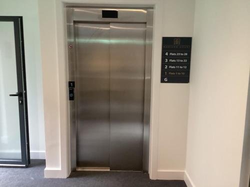 a elevator in a building with a sign on it at Hemel Apartments- Sunset retreat in Hemel Hempstead