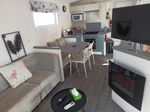 un petit salon avec un canapé et une table dans l'établissement Mobile-home La Carabasse FO88, à Vias
