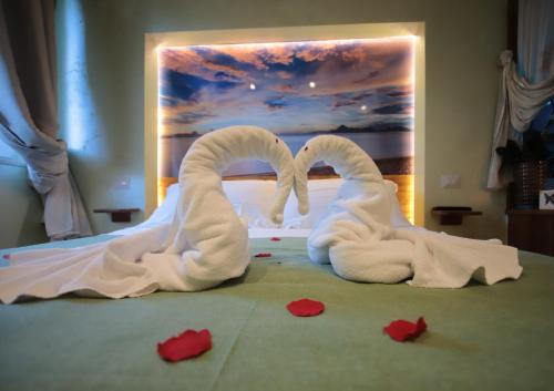 dois animais de toalha em forma de cisnes sentados numa cama em Dream & Relax Villa Fiore em Bari
