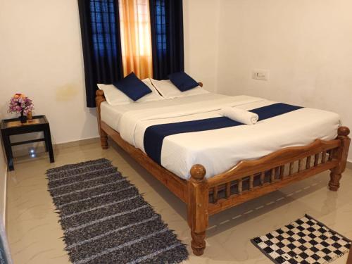 1 dormitorio con 1 cama grande con sábanas azules y blancas en Coorg Get Inn Home Stay, en Madikeri