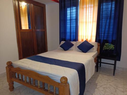 1 dormitorio con 1 cama grande con almohadas azules en Coorg Get Inn Home Stay, en Madikeri