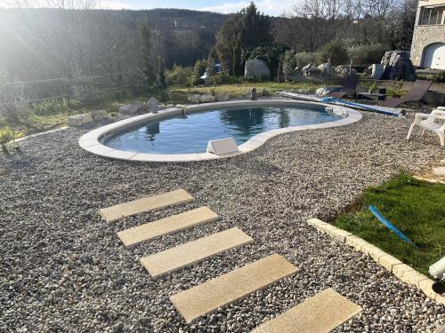 a small pool in the middle of a gravel yard at Brugière in Vogüé