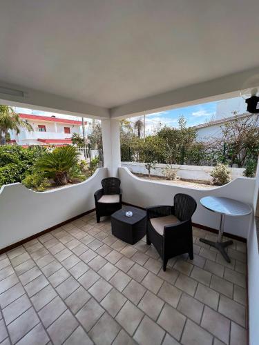 a patio with chairs and a table and two windows at Villa Gianna in Taranto