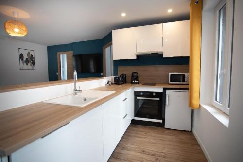 a kitchen with white cabinets and a sink at Escapade Eudoise in Eu