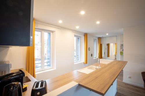 a kitchen with a wooden counter top and some windows at Escapade Eudoise in Eu
