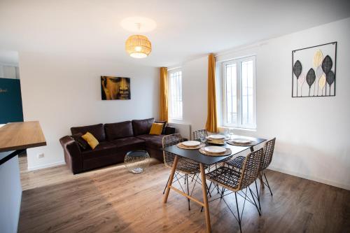 a living room with a table and a couch at Escapade Eudoise in Eu