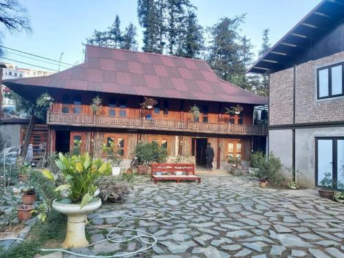 a large house with a stone patio in front of it at Green Sapa Homestay in Sa Pa