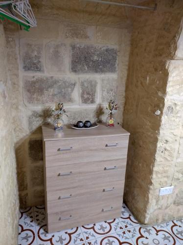 a dresser in a room with a stone wall at Sixty Two #4 in Victoria
