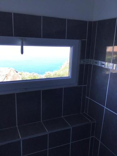 - une fenêtre dans la salle de bains avec vue sur l'océan dans l'établissement Casa giuliani, à Barrettali