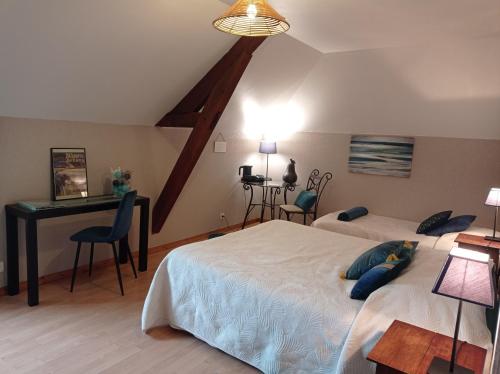 a bedroom with two beds and a desk in it at Chambres d'Hôtes Au Moulin 