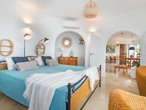 een slaapkamer met een blauw bed en een woonkamer bij Casa Calma in Cala Santanyi