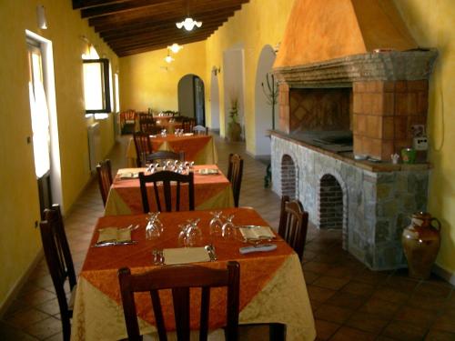 un ristorante con due tavoli e un camino in pietra di Agriturismo Masseria Castiglione a Gallicchio
