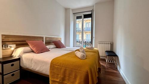 een slaapkamer met twee bedden en een raam bij Larramendi City Center in San Sebastian